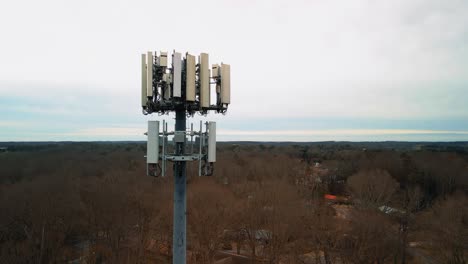 aerial shot reversing to show cell phone tower in forest