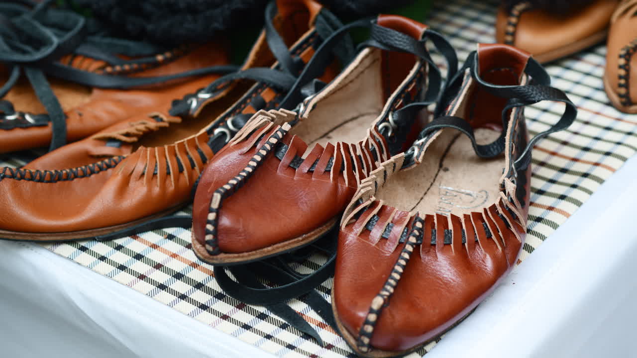 Handmade Moldavian and Romanian Opinca leather shoes at a vibrant artisan market