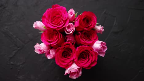 Ramo-De-Rosas-Rosadas-Embalado-En-Caja-Roja-Y-Colocado-Sobre-Fondo-De-Piedra-Negra
