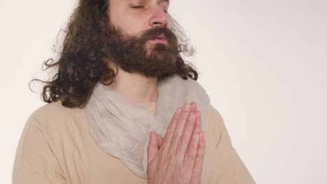 portrait of man wearing robes with long hair and beard representing figure of jesus christ raising hands in prayer 2