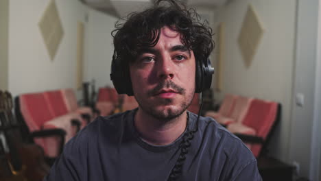 músico editor profesional trabajando en el estudio con auriculares de cerca