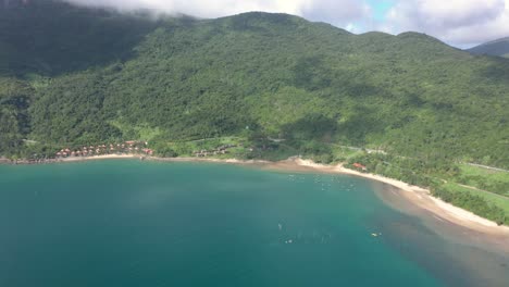 antena de impresionante costa con agua azul cristalina y pequeños barcos de pesca y pescadores en el sudeste asiático