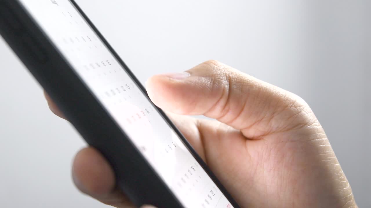 Man looking at calendar dates on a smartphone. schedule for summer holiday vacation, business meetings, appointments, new initiatives concept. 4K Resolution