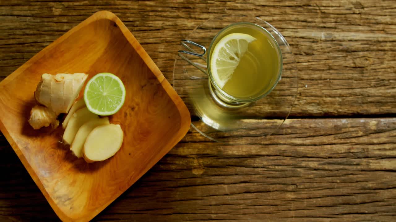 té de limón con jengibre y limón en una mesa de madera 4k