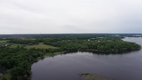 Super-high-and-wide-aerial-shot-of-a-Midwestern-lake-as-storm-moves-in