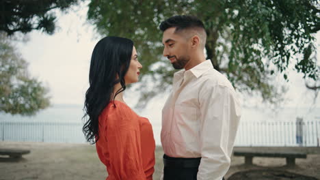 Lovely-couple-standing-park-close-up.-Two-people-enjoy-romantic-date-outdoors.