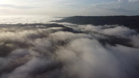 aerial view of a mountain with fog or white clouds in the morning