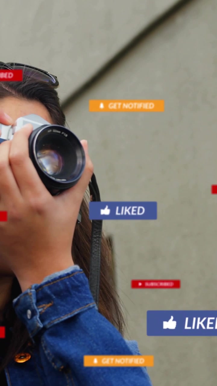 Woman in denim jacket with shades framing film camera to shoot building, notifications appearing