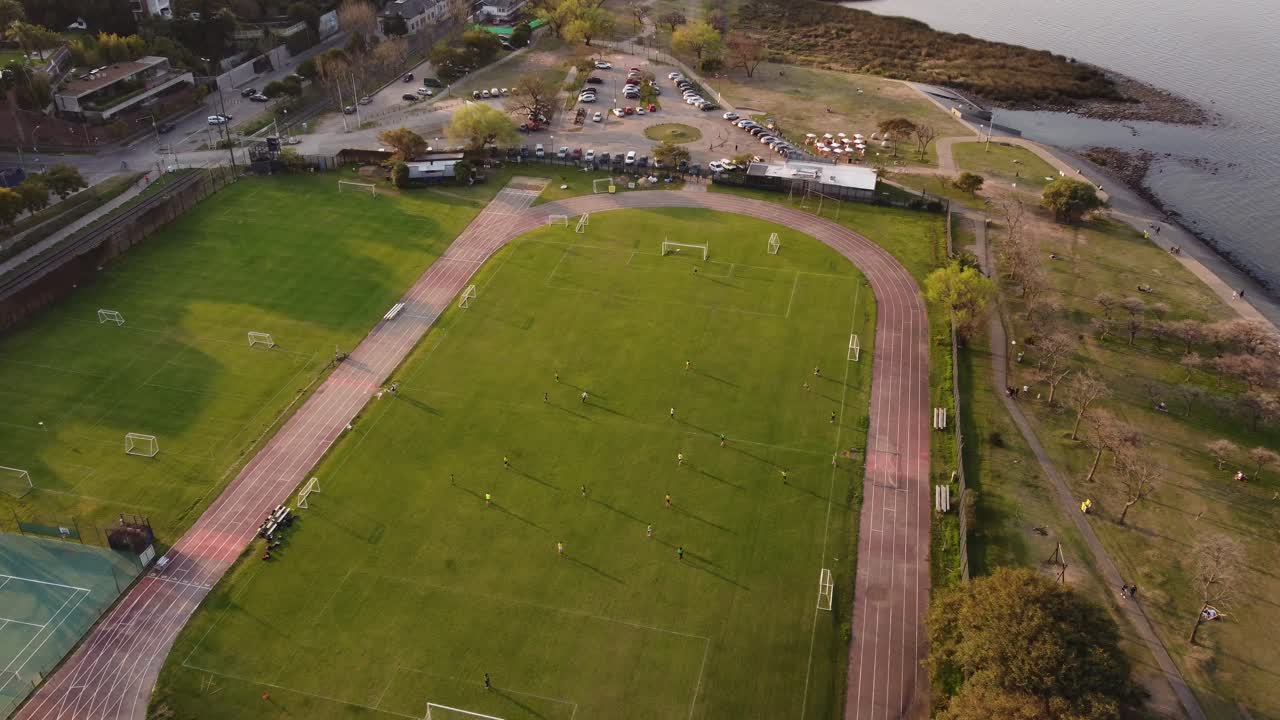 Aerial flyover soccer field during football game between women during sunset - River Plate in Buenos Aires