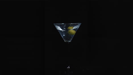 martini with olives in splash