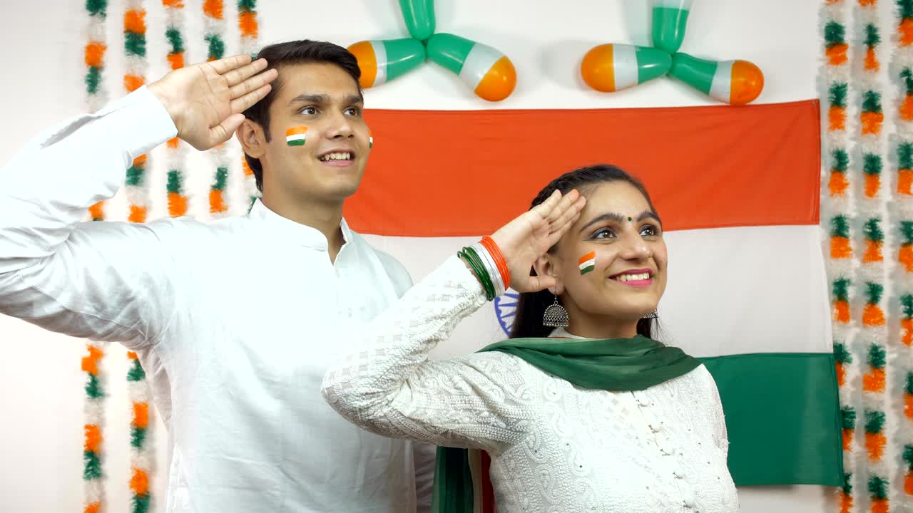 Adolescenti indiani che salutano la bandiera indiana guardando il cielo - Giorno dell'Indipendenza