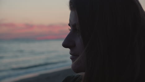 Cerca-De-Una-Chica-Parada-En-La-Playa,-Mirando-Al-Océano-Al-Atardecer-Y-Pensando-En-Recuerdos