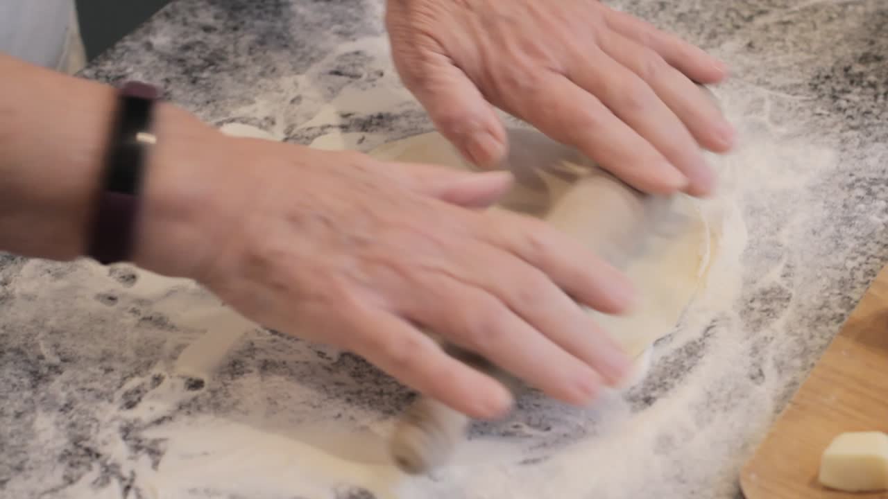 повар урожая разворачивает выпечку на столе в доме