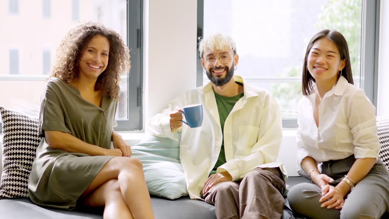 Coworkers smiling relaxed during coffee break sitting on comfortable chairs