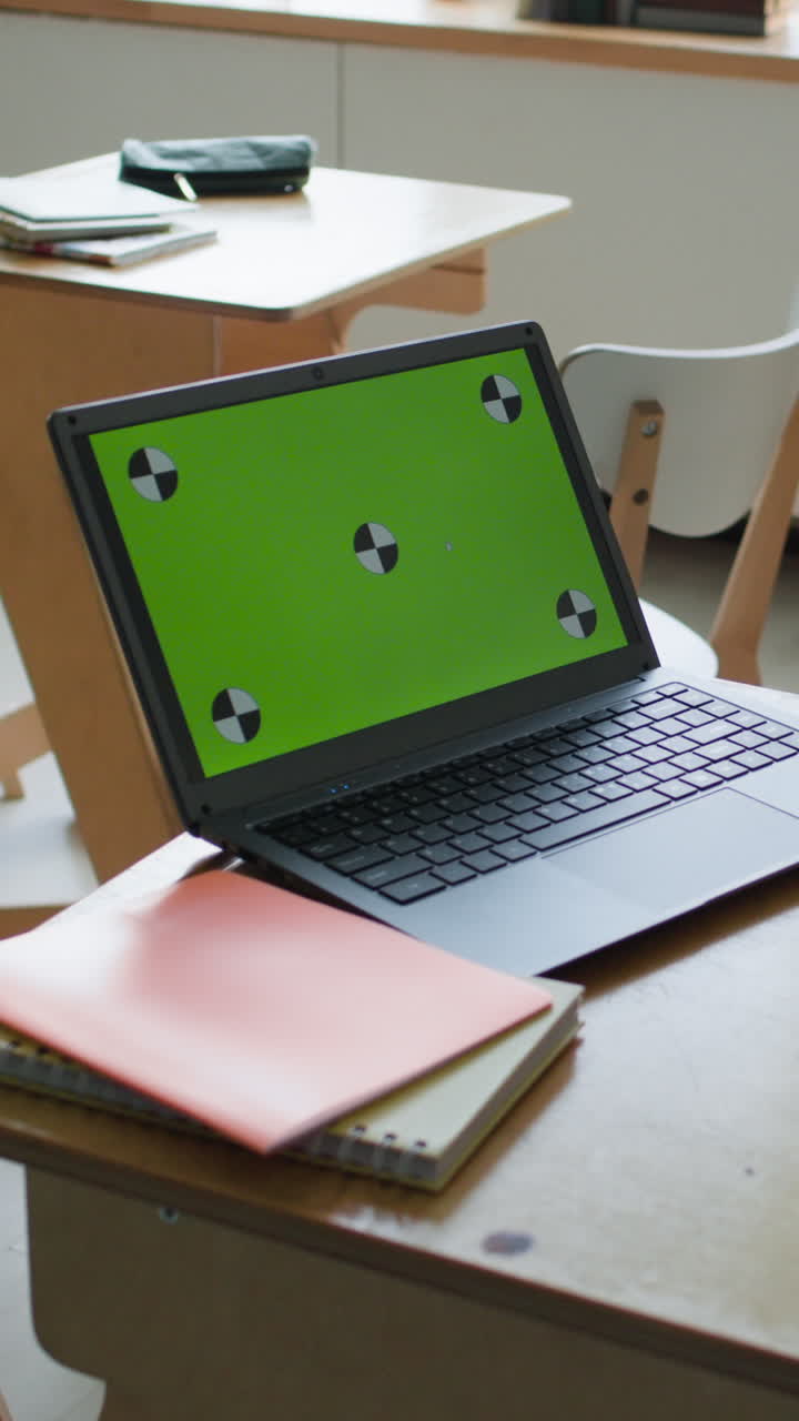 Laptop on a school desk with green screen