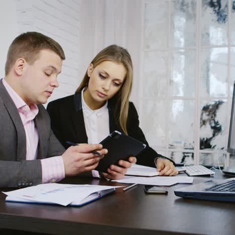 Young-Businessman-and-Businesswoman-Discussing-Project