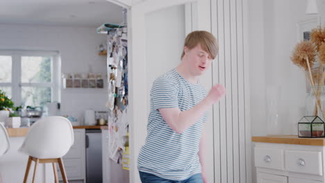 young downs syndrome man having fun dancing at home