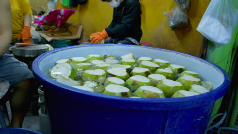 Der-Prozess-Der-Herstellung-Von-Kokosgelee,-Einem-Berühmten-Thailändischen-Straßenessen,-Das-Aus-Kokosraspeln-Hergestellt-Wird,-Die-In-Einem-Großen-Behälter-In-Wasser-Getaucht-Werden