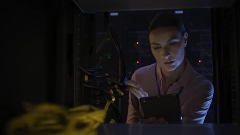 técnica informática caucásica que usa una tableta para comprobar el servidor de la computadora