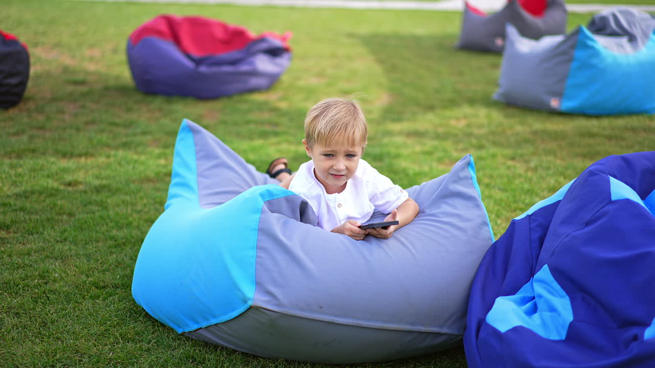 Boy using mobile phone in a park