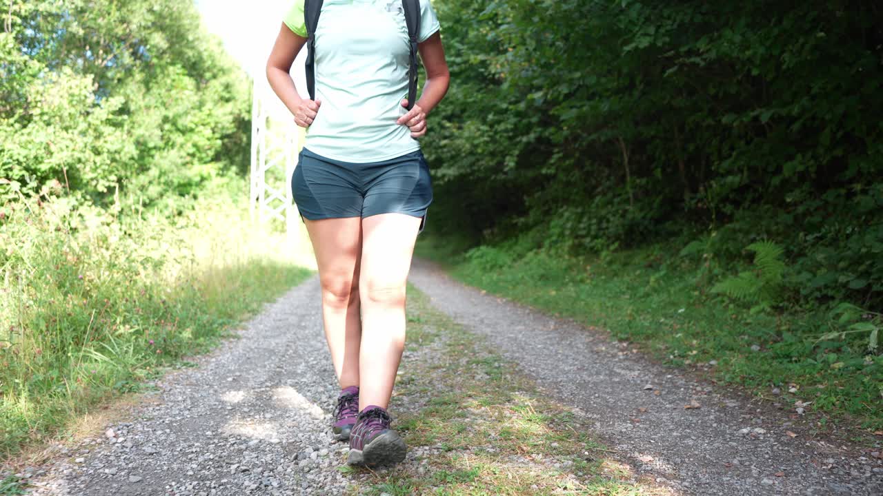 Donna che fa un'escursione sul sentiero della foresta