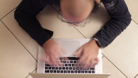 Lapso-De-Tiempo:-Primer-Plano-De-Un-Hombre-Caucásico-Escribiendo-En-El-Teclado-De-Un-Portátil,-En-El-Suelo