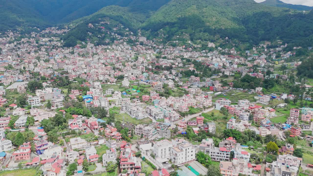 Aerial drone footage of Budhanilkantha in Kathmandu Valley, Nepal, showcasing city settlements, green hills, and scenic mountain landscapes from above