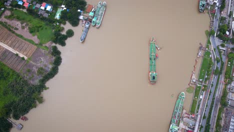 aerial birds eye view of liquid tanker being pushed by tugs on chao phraya river