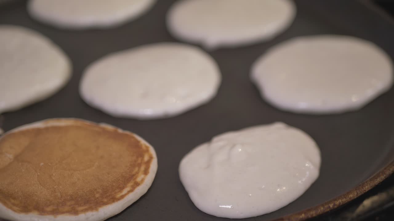 masa vertida con una cuchara en una sartén caliente