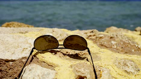 sunglasses lying on stone fence