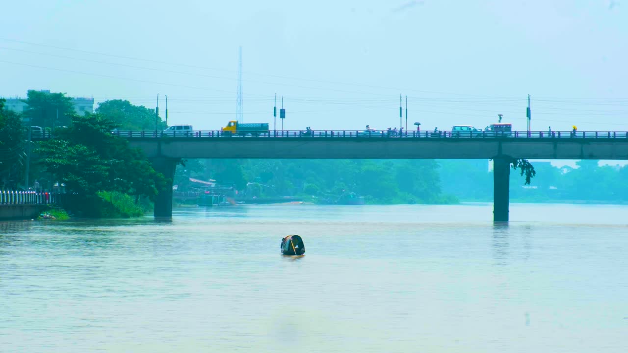 방글라데시 의 도로 다리 에서 운행 되는 차량 들 과 함께 수르마 강 에서 보트 를 항해 하는 것