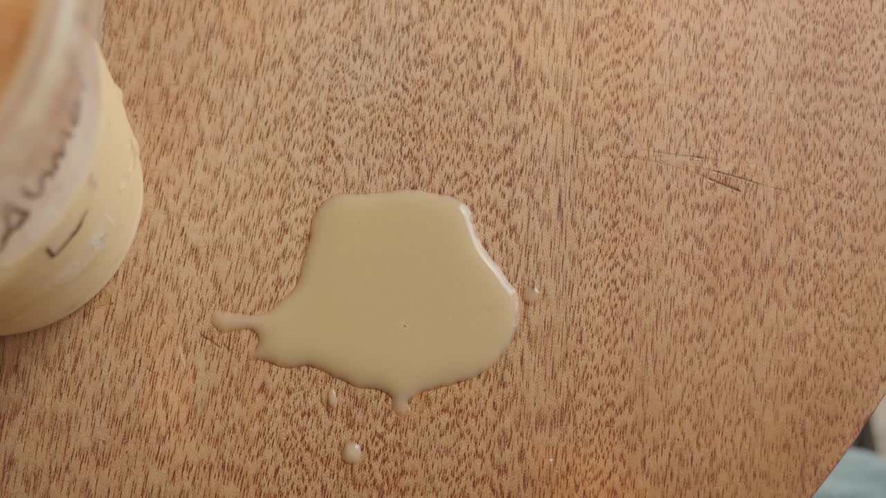 Liquido beige versato su una superficie in legno