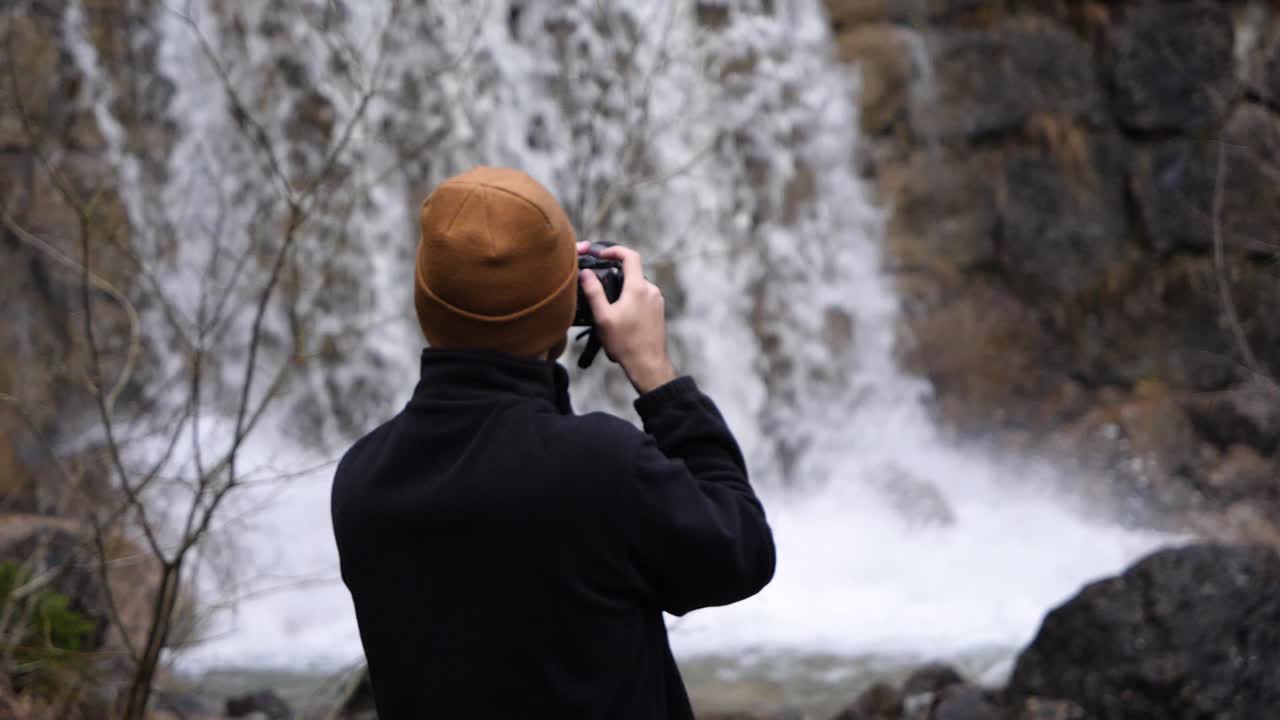 Switzerland Tourist Photographer Taking a Photo of a Beautiful Waterfall