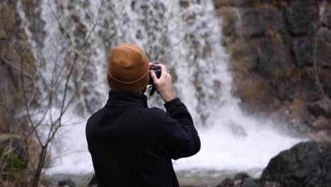 switzerland tourist photographer taking a photo of a beautiful waterfall