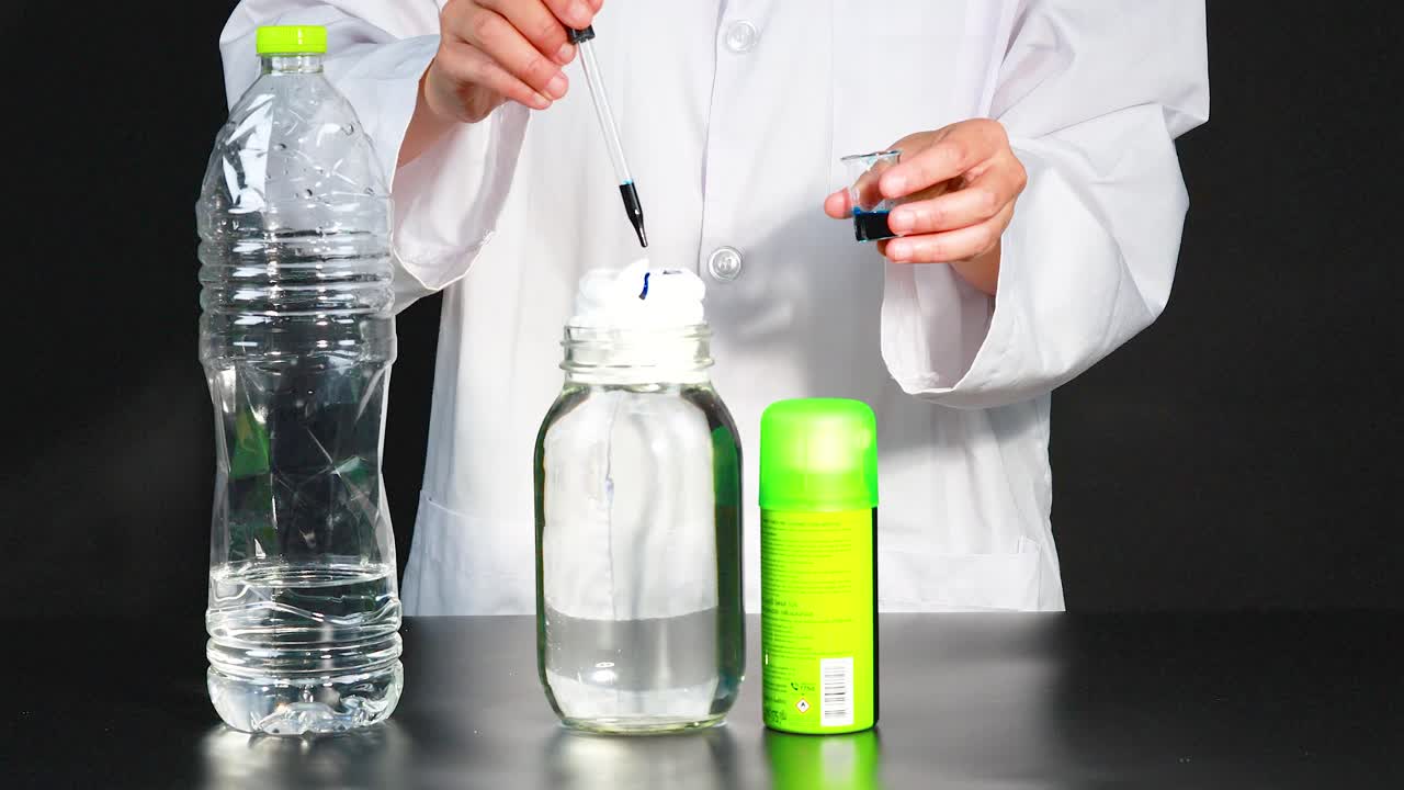 실험실 코트를 입은 아이들은 실험실 환경에서 컵, 염료 및 피을 사용하여 활기찬 화학 반응을 수행합니다.