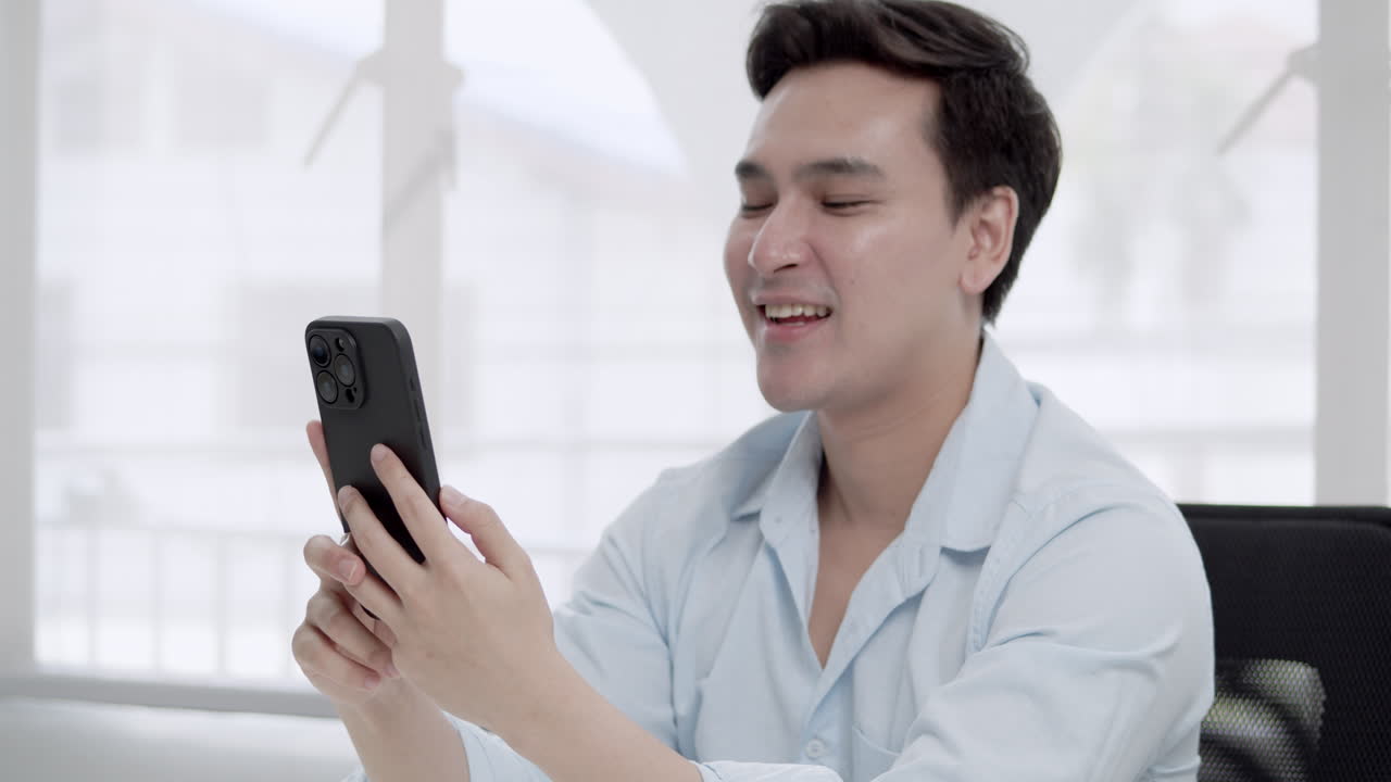A cheerful young man enjoys a virtual chat highlighting the importance of digital connections in modern life.
