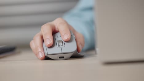 close-up hand of a businessman using wireless or bluetooth mouse. scrolling the wheel working with a pc or laptop.