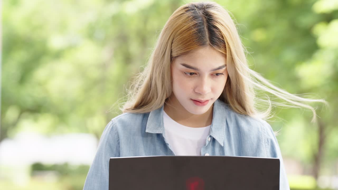 Two Asian girls student partners are working on a laptop help study together