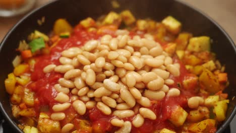 persona anónima preparando un apetitoso gratin de tomate y frijol