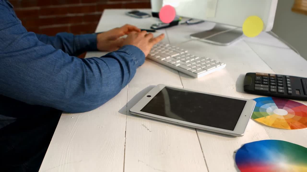 diseñador gráfico masculino usando una tableta digital mientras trabaja en la computadora