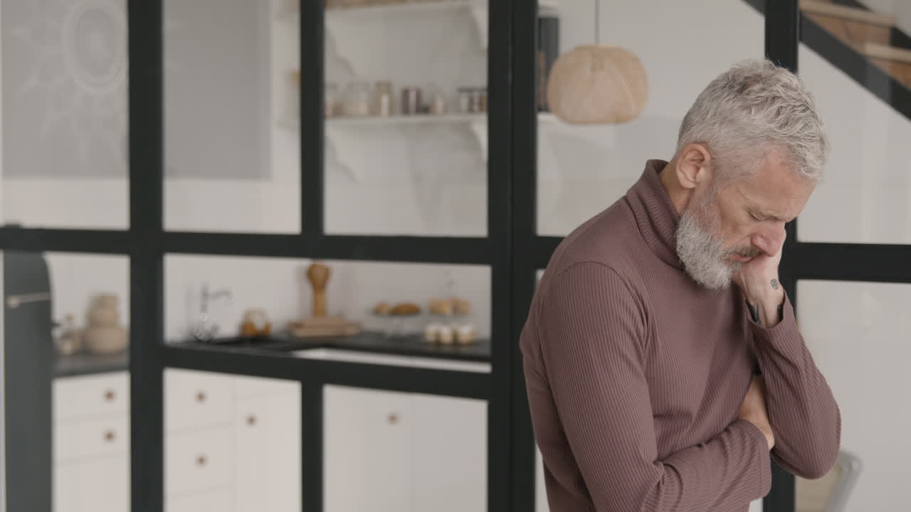 hombre de mediana edad con dolor de cabeza en casa mientras su esposa intenta consolarlo