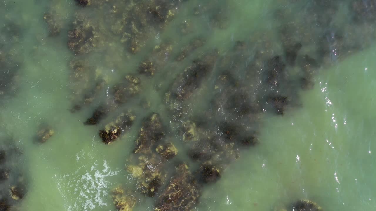 Vista aerea dall'alto in ascesa della marea che avanza sulle rocce a Brighton Beach, Regno Unito.