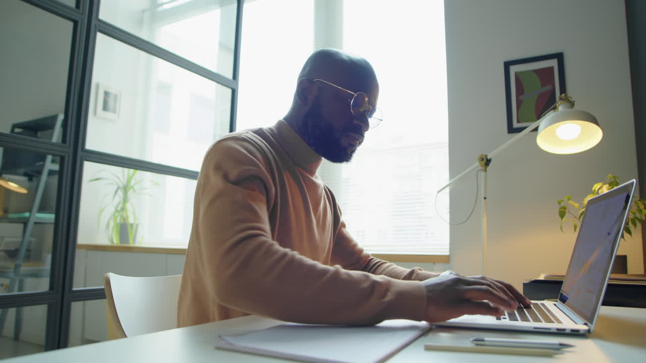 Black Businessman Working on Laptop in Office