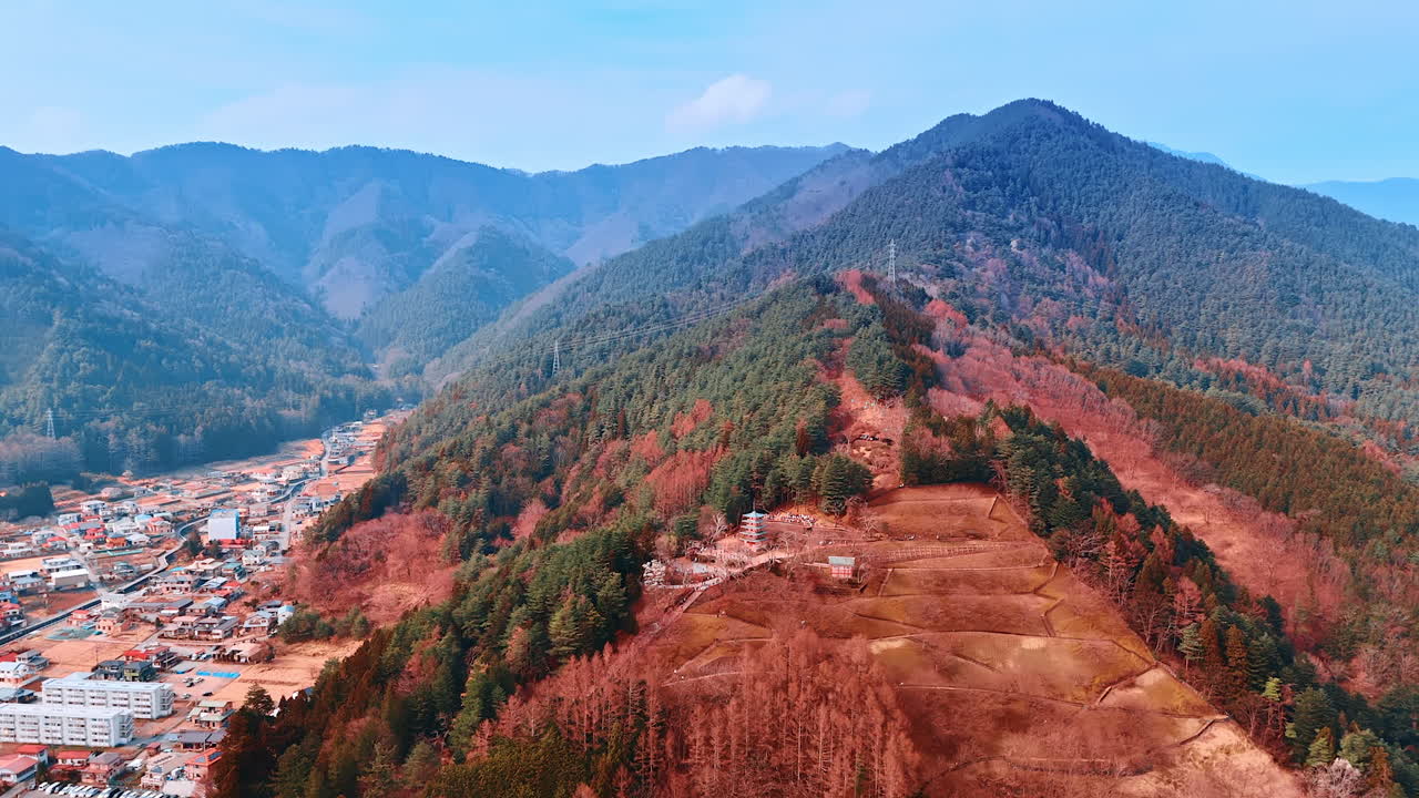 Pine tree woods covering the mountains that surround cityscape. Aerial perspective on Mount Fuji, Japan. Top view.