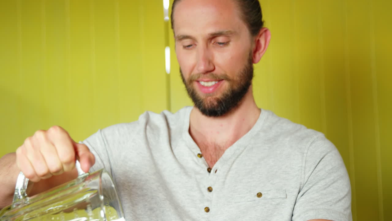 hombre vertiendo jugo de naranja en una botella