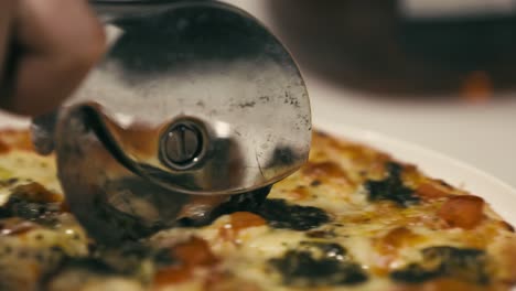 a cook cuts a small pizza into eight slices