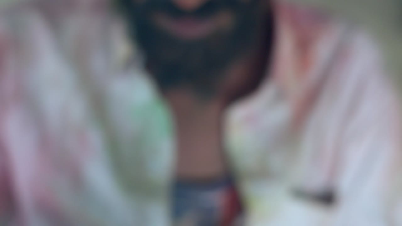 hombre indio de primer plano de la cara manchada con colores brillantes de holi