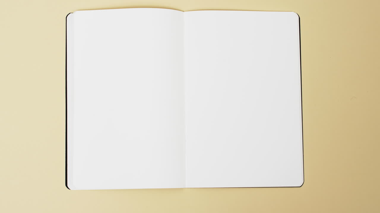 Video of book with white blank pages and copy space on yellow background
