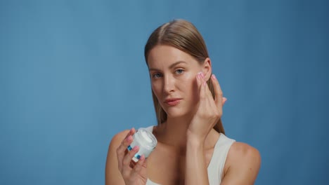 mujer aplicando crema facial