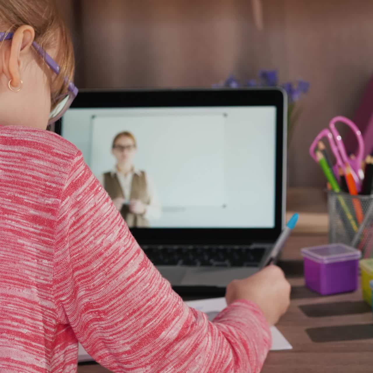 la niña está en casa frente a su computadora portátil enfocándose en una lección en línea